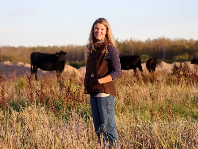 female farmer in field with cattle
